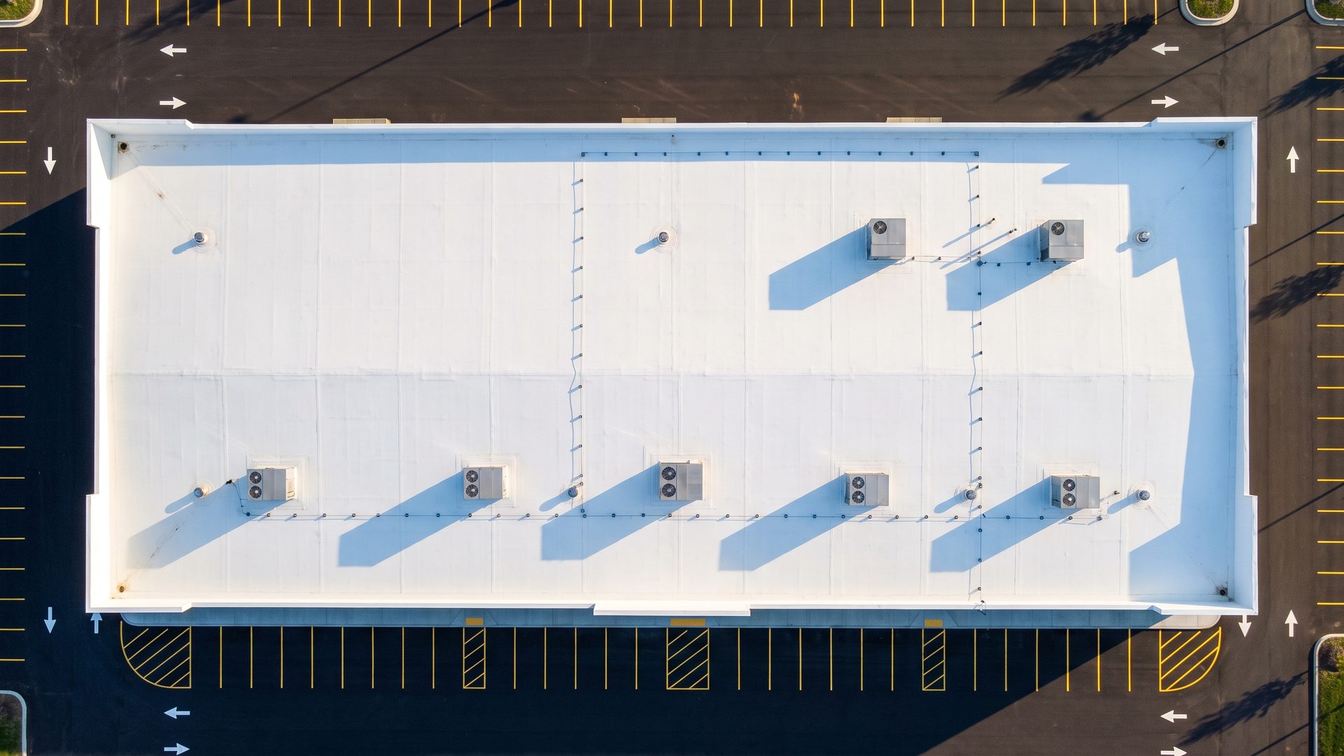 Illustration of a commercial warehouse roof with a new white membrane